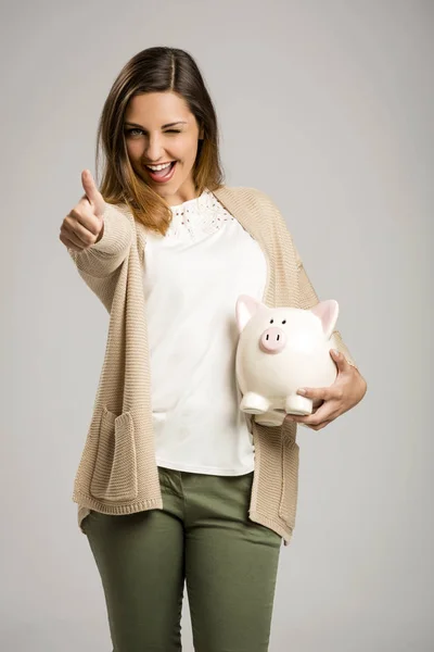 Szczęśliwa kobieta gospodarstwa piggy bank — Zdjęcie stockowe