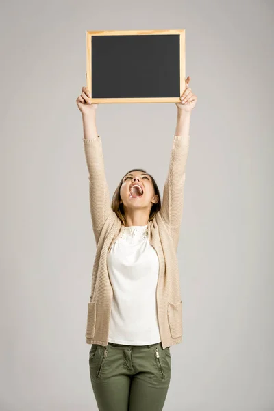Woman holding empty chalkboard — Stock Photo, Image