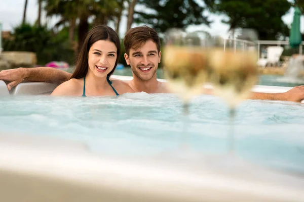 Casal jovem descansando em jacuzzi — Fotografia de Stock