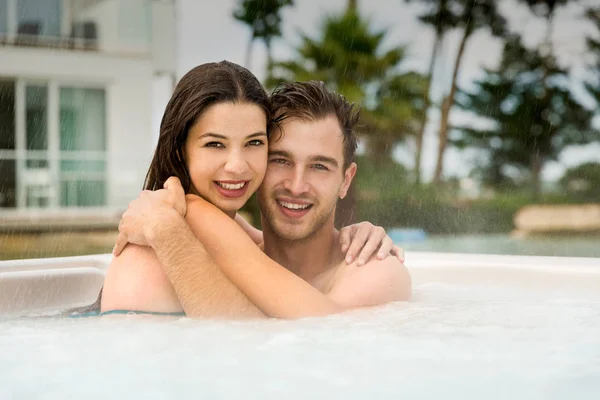 Giovane coppia a riposo nella vasca idromassaggio — Foto Stock