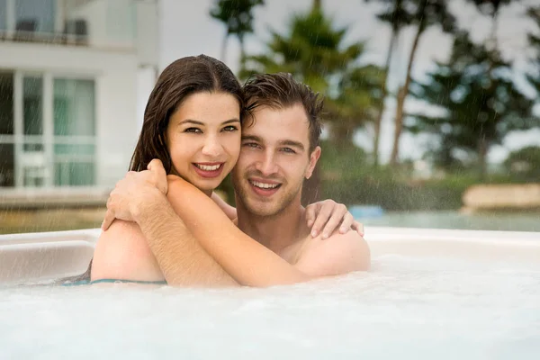 Casal jovem descansando em jacuzzi — Fotografia de Stock