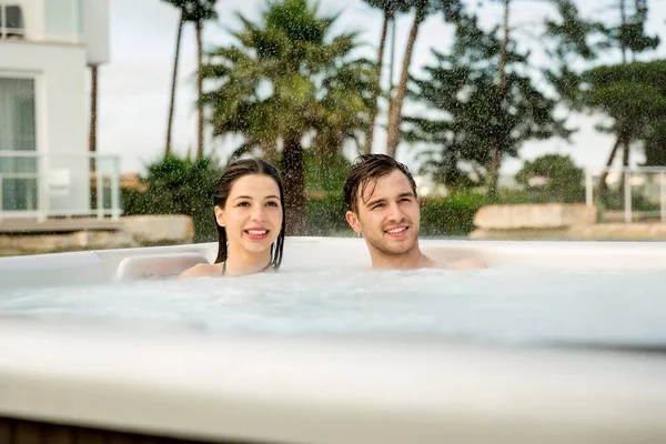 Casal jovem descansando em jacuzzi — Fotografia de Stock