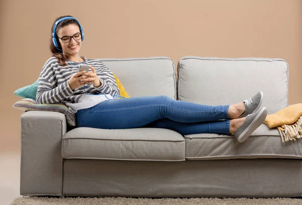 Mulher no sofá ouvindo música — Fotografia de Stock