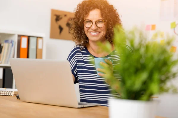 Mulher no escritório trabalhando com laptop — Fotografia de Stock