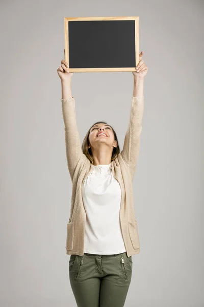 Beautiful woman holding chalkboard — Stock Photo, Image