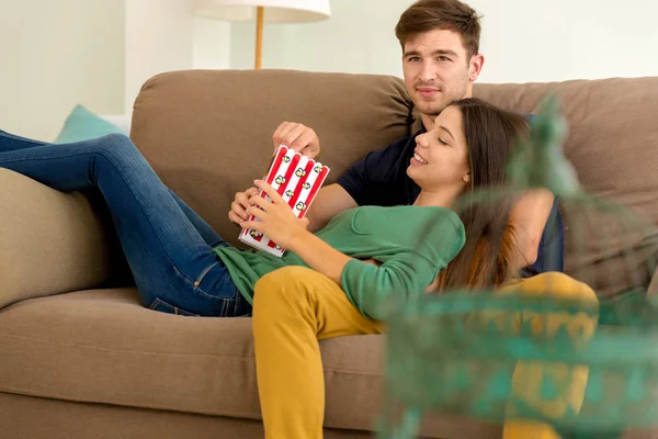 Pár eszik popcorn kanapé — Stock Fotó