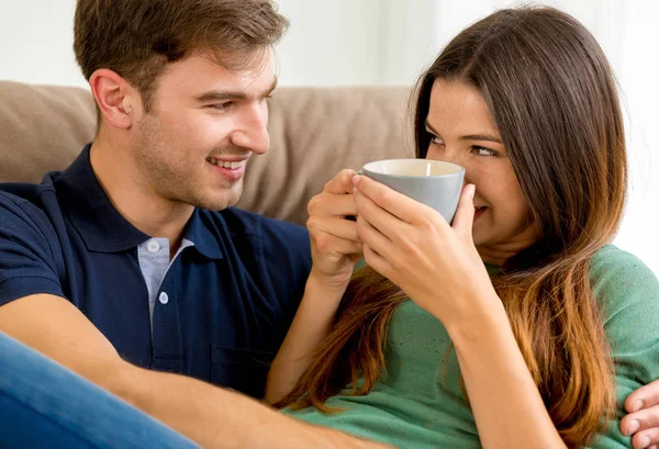 Paar trinkt Kaffee auf dem Sofa — Stockfoto