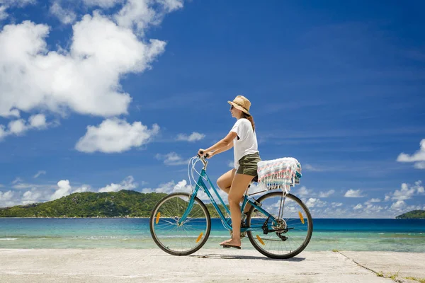 Vrouw op fiets rijden langs strand — Stockfoto