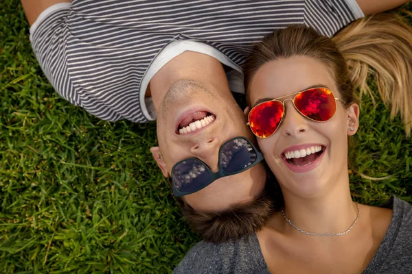 Hermosa pareja acostada en la hierba — Foto de Stock