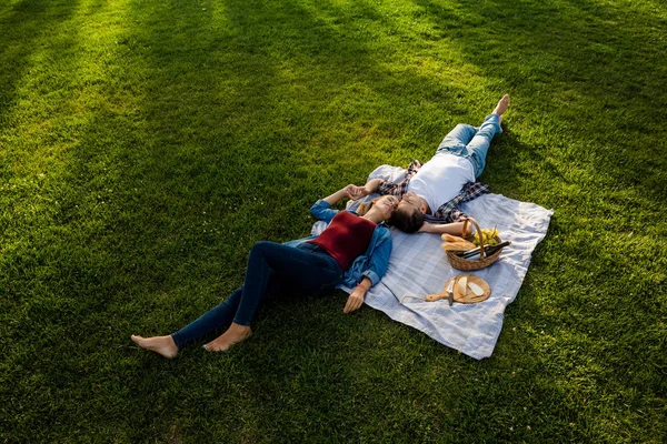 Casal relaxante no parque após piquenique — Fotografia de Stock