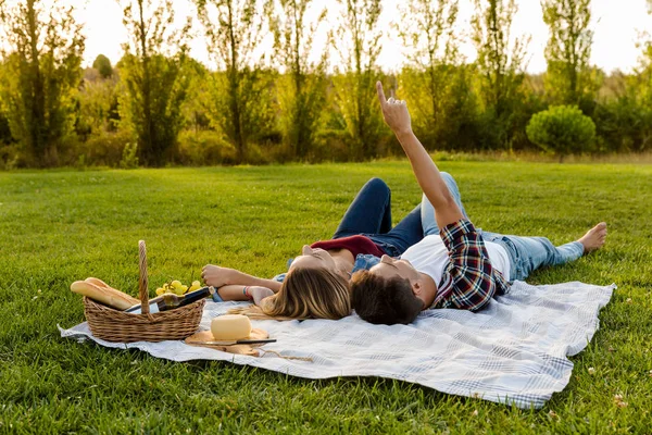 Par avkopplande i parken efter picknick — Stockfoto