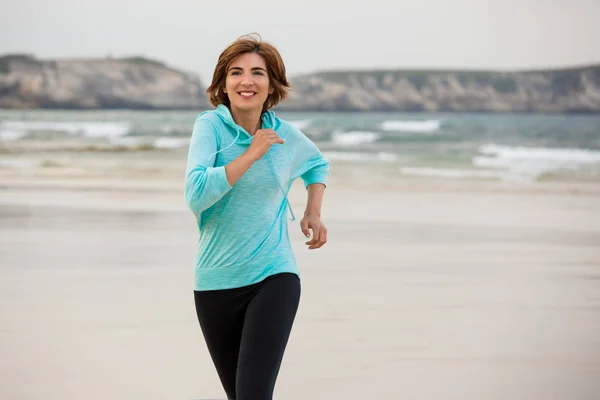Žena běží na pláži — Stock fotografie