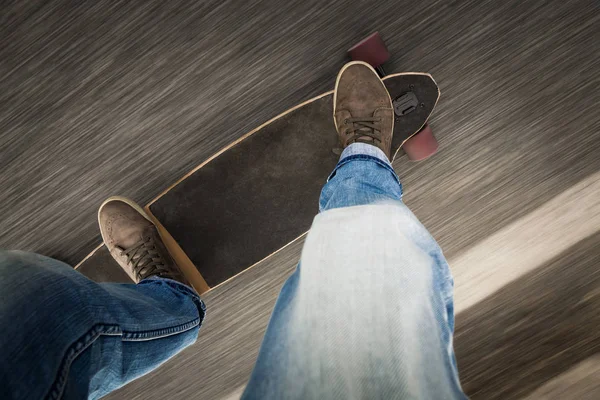 Giovane uomo piedi cavalcando uno skateboard — Foto Stock