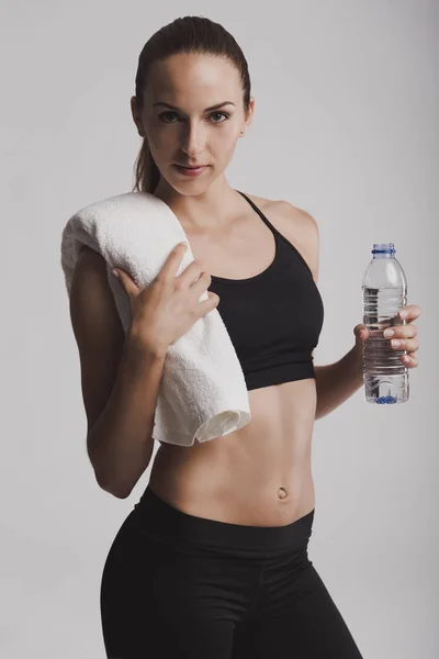 Woman holding water bottle and towel — Stock Photo, Image