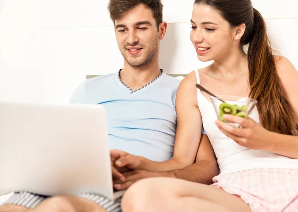 Pareja en la cama con ordenador portátil —  Fotos de Stock