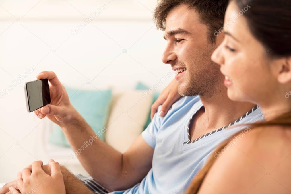Couple on bed watching videos 