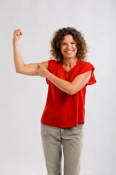 Brunette pointing to her muscle — Stock Photo, Image
