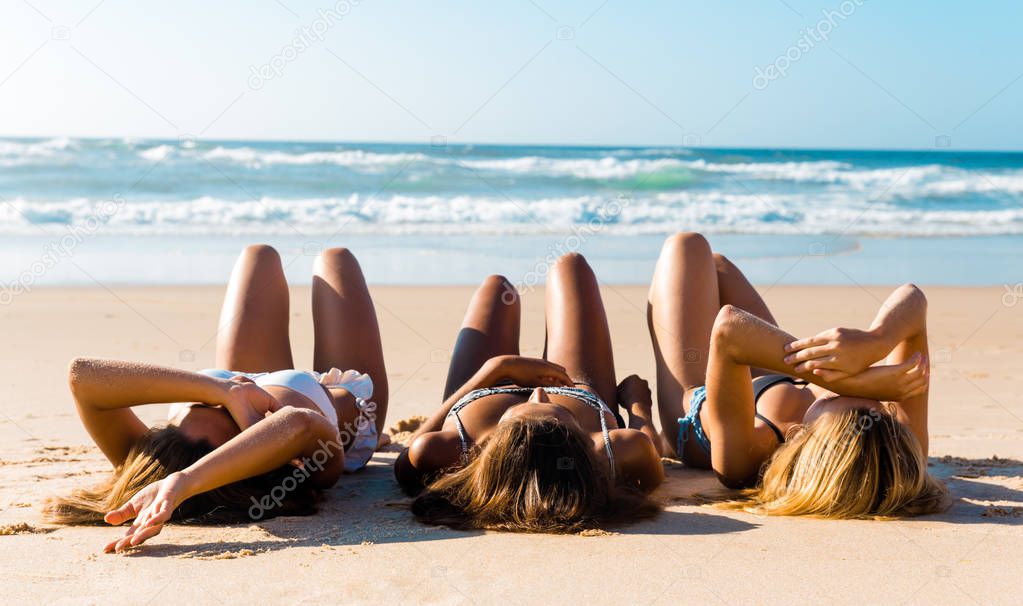 Beautiful girls lying on sand