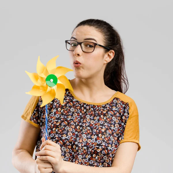 Frau bläst Windmühle — Stockfoto