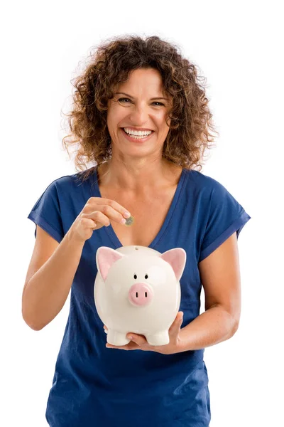 Mulher colocando dinheiro em um Piggybank — Fotografia de Stock