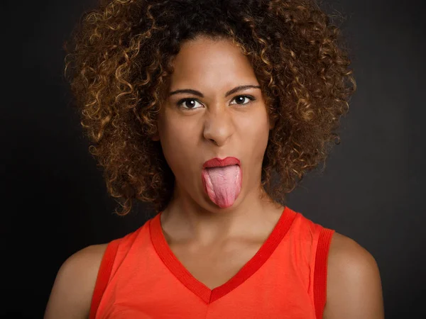 Vrouw trekt haar tong uit — Stockfoto
