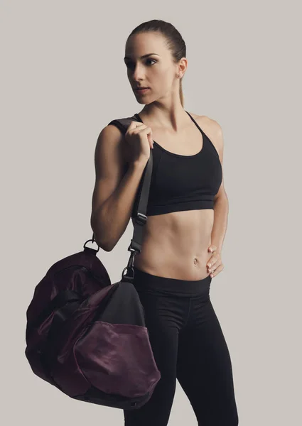 Vrouw poseren met een sporttas — Stockfoto