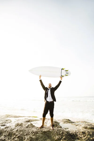 Affärsman som höjer upp surfbräda — Stockfoto