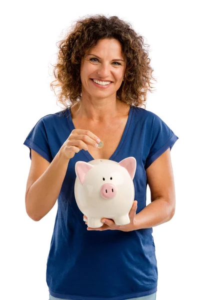 Mujer poniendo dinero en una alcancía — Foto de Stock