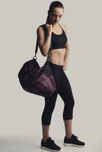 Vrouw poseren met een sporttas — Stockfoto