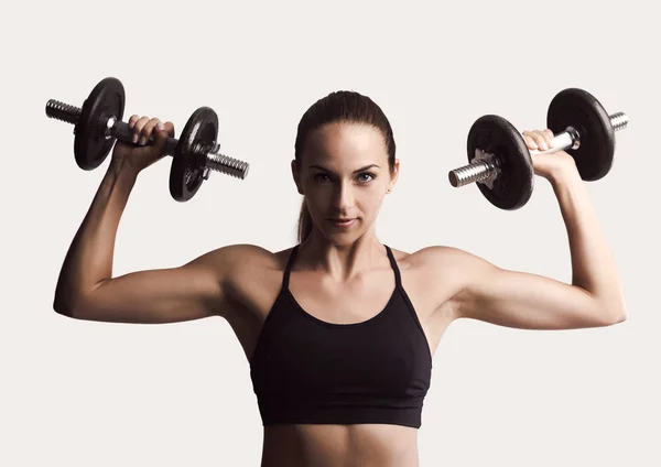 Mujer en un equipo de entrenamiento levantamiento de pesas —  Fotos de Stock