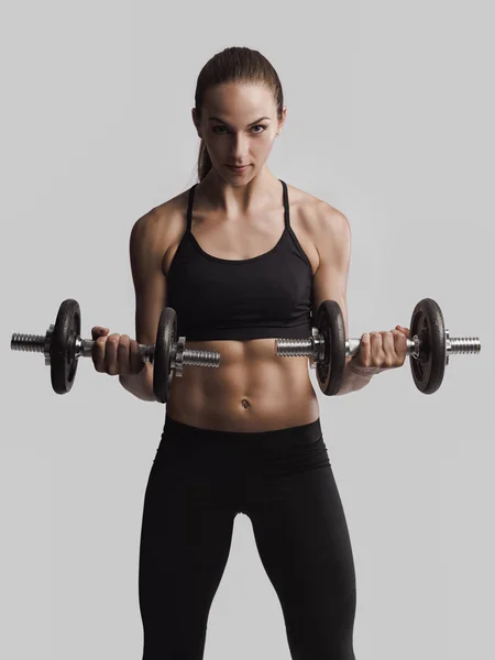 Mujer en un equipo de entrenamiento levantamiento de pesas —  Fotos de Stock