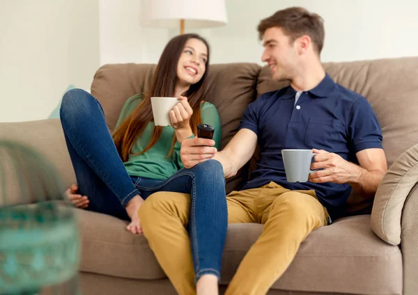 Coppia sul divano bere caffè — Foto Stock