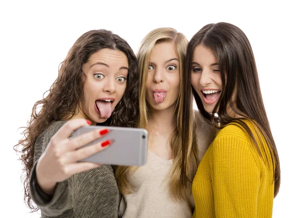 Девушки со смартфоном делают селфи — стоковое фото