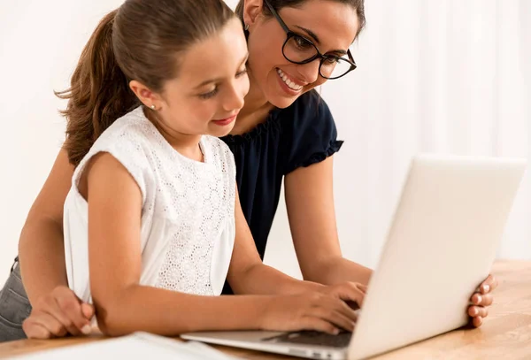 Mutter lehrt Tochter, die mit Laptop arbeitet — Stockfoto