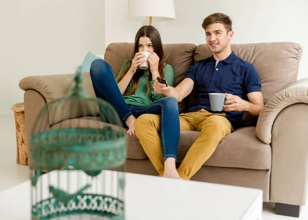 Пара смотрит телевизор и пьет кофе — стоковое фото