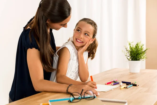 Mère aidant sa fille avec ses devoirs — Photo