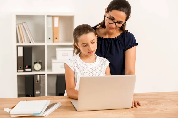 Mother helping her daughter with homework — Stock Photo, Image
