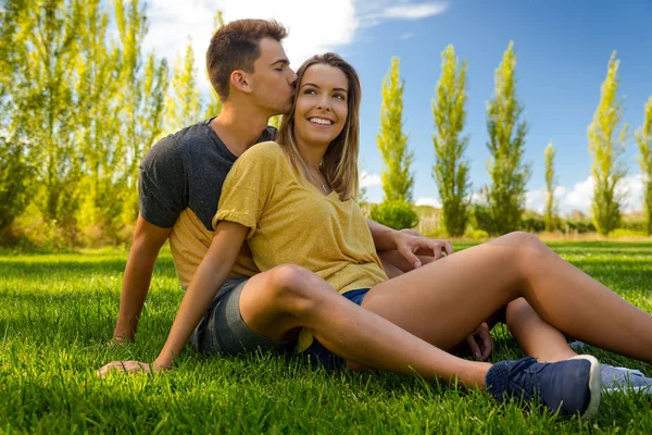 Pareja sentada en la hierba —  Fotos de Stock