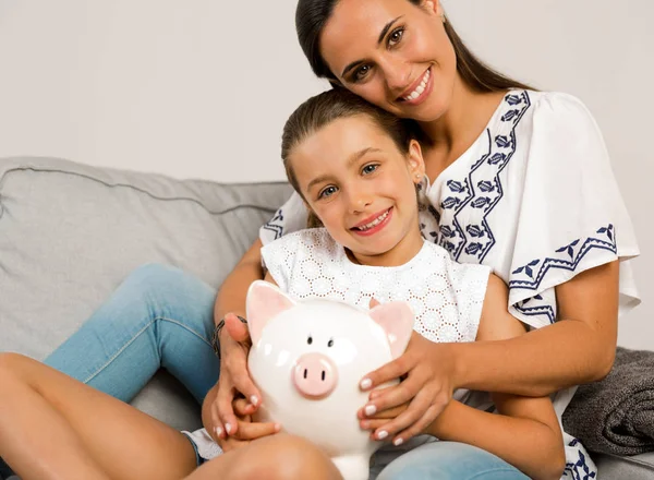 Mãe e filha com piggybank — Fotografia de Stock