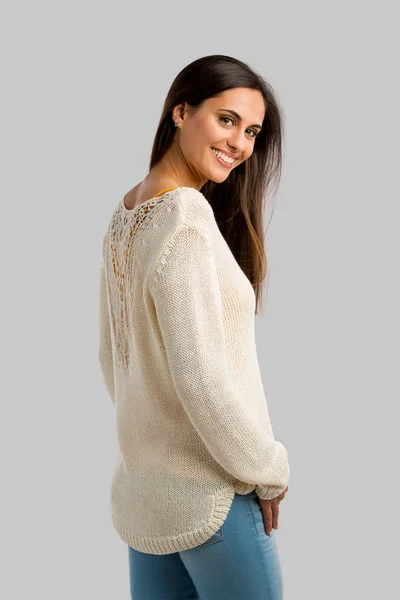 Mladá usměvavá žena v béžové svetru — Stock fotografie
