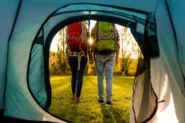 Mladý pár s batohy na louce — Stock fotografie