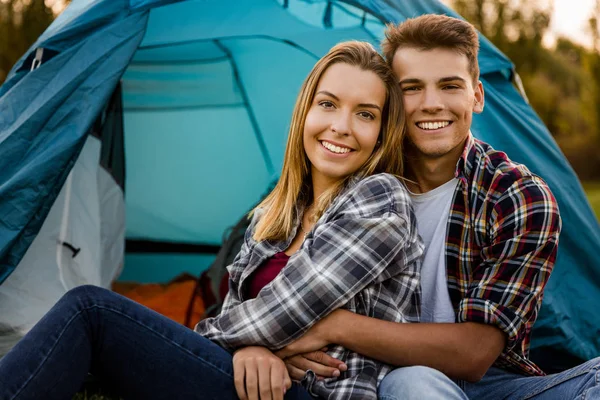 Casal feliz sentado perto da tenda ao ar livre — Fotografia de Stock