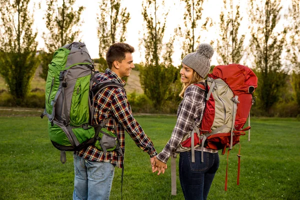 Jovem casal com mochilas no prado — Fotografia de Stock