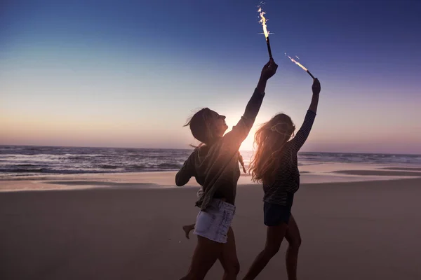 Freundinnen laufen mit Feuerwerk — Stockfoto