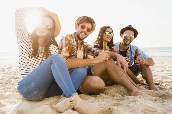 Friends drinking beer on beach — Stock Photo, Image