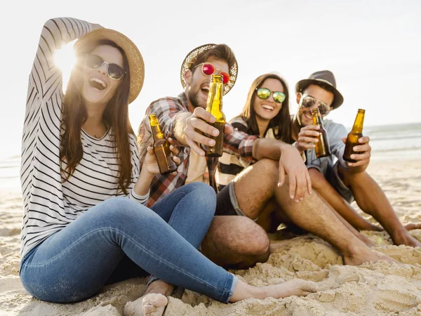 Vänner dricker öl på stranden — Stockfoto