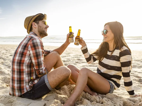 夫妇在海滩上喝啤酒 — 图库照片