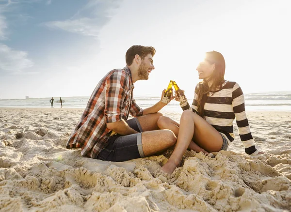 Coppia bere birra sulla spiaggia — Foto Stock