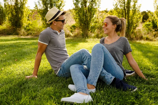 Paar elkaar op gras zitten — Stockfoto