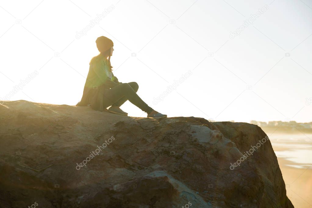 Woman sitting on cliff